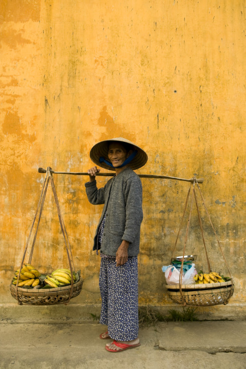 old vietnamese woman balance basket market vietnam smiling yello